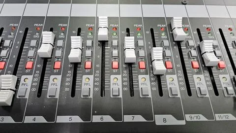 Close-up sliders, buttons and knobs of audio mixer in broadcast studio. Stockfoto's