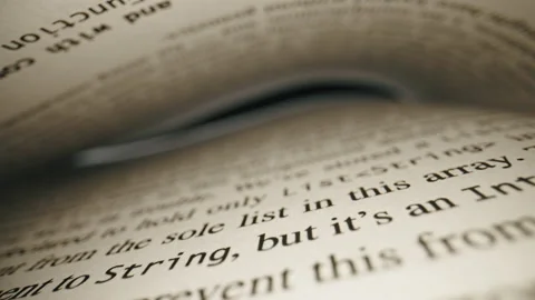 Close-up sliding over English text between pages, inside a book with laowa probe Stock Footage 229799996