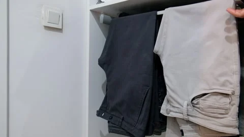 Close-Up of Sliding Pants Hanger in Modern Dressing Room Wardrobe with Hand Stock Footage 302686952