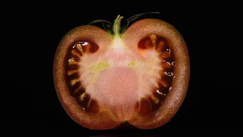 Close up of slit pink tomato with stem, rotating on black background Stock Footage 74884306