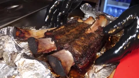 Close-up of Slow-Cooked BBQ Beef Short Ribs on Aluminum Foil Stock Footage 338212796