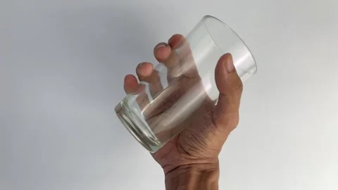 Close-Up of Slow Hand Shaking of a Clear Glass on a White Background Video stock 307086539