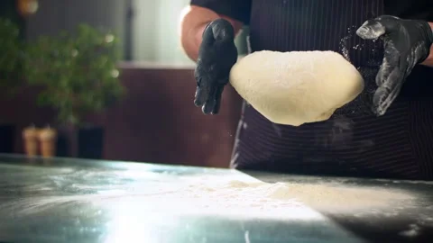 Close-up slow mo shot of chef's hands dropping dough into flour Stock Footage 137318799