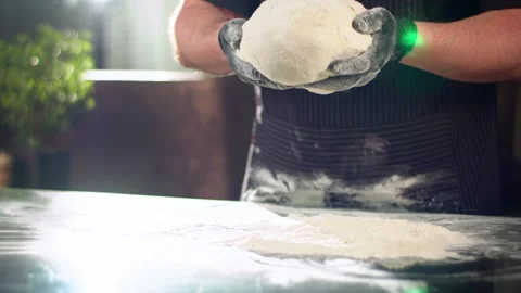 Close-up slow mo shot of chef's hands dropping dough into flour Stock Footage 137318834