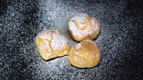 Close up slow-motion 2 Eclairs with more icing on top black background Видео 135641678