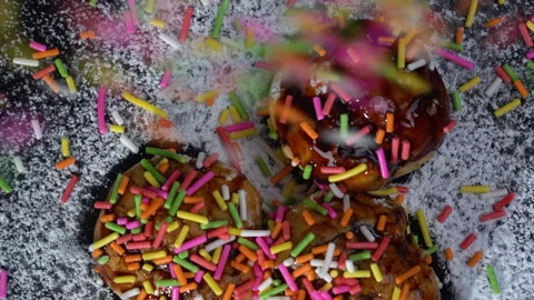 Close up slow-motion 3 Eclairs chocolate glaze with rainbow sprinkles ontop Stock-Footage 135641749