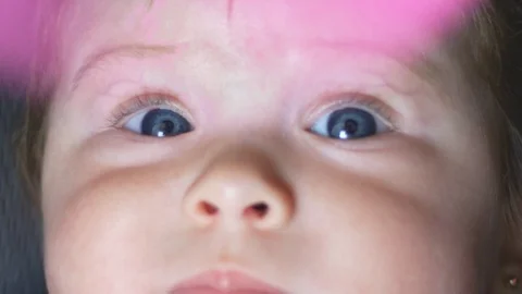 Close-up in slow motion of baby's beautiful blue eyes with moving fan on top Stockbeeldmateriaal 114103973