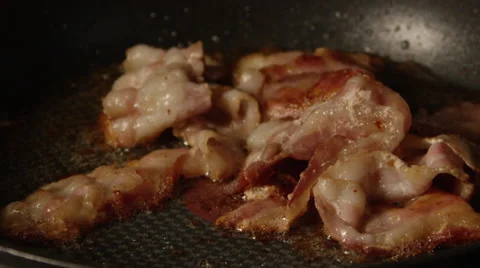 Close up slow motion bacon frying in pan Stock Footage 58890957