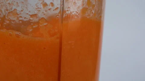 Close up slow motion, blending the carrot juice from a piece of carrot. 库存影片 137769441