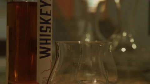 Close up slow motion of bottle of whiskey and glasses on bar counter Stock Footage 204767457