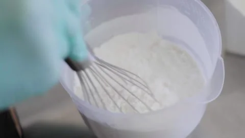 Close-up, Slow Motion, Chef's Hand in Glove Stirs With a Flour Whisk in a Stock Footage 136776478