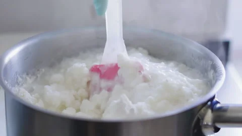 Close-up, Slow Motion, Chef's Hand in Glove Stirs Milk Cream Boiling in Metal Stock Footage 136778232