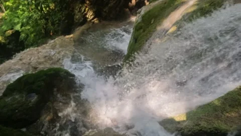 Close up slow motion of a clear waterfall flowing in the mountains Stock Footage 321860457