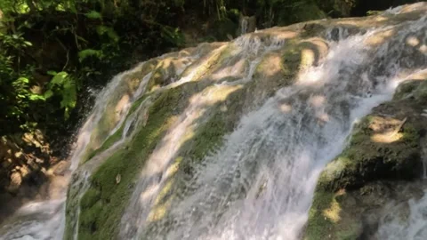 Close up slow motion of a clear waterfall flowing in the mountains Stock Footage 321860462