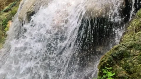 Close up slow motion of a clear waterfall flowing in the mountains Stock Footage 321860490