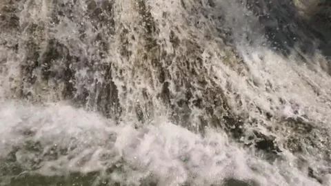 Close up slow motion of a clear waterfall flowing in the mountains Stock Footage 321860535