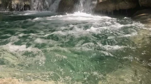 Close up slow motion of a clear waterfall flowing in the mountains Stock Footage 321860537