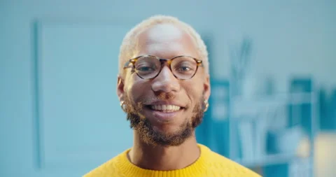 Close up slow motion confident black male model wearing glasses and smiling Stock Footage 163146613