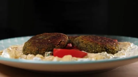 Close up slow motion of cooked falafel falling on plate with a tortilla wrap. Video stock 154712894