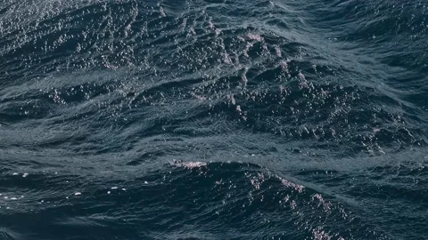 Close-up slow motion of a disturbed blue ocean water surface. Nice loop backgrou Video stock 234419483