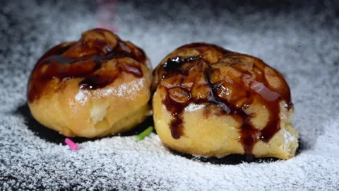 Close up slow-motion Eclairs chocolate glaze with rainbow sprinkles on top Видео 135641894