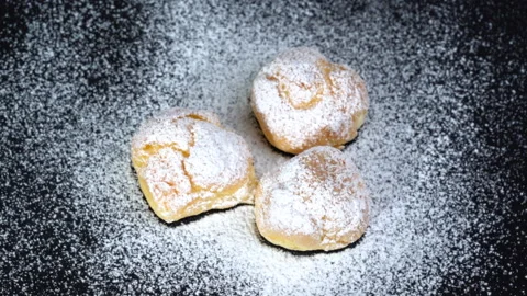 Close up slow-motion Eclairs with more icing on top black background. Видео 135641674
