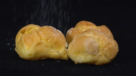 Close up slow-motion Eclairs with more icing on top black background Видео 135641736