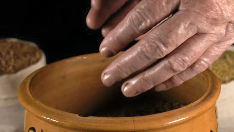 Close-Up, Slow Motion, Elderly Woman's Hands Take Wheat Grains From Clay Pot And Stock Footage 91096954