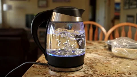 Close-Up Slow Motion of Electric Kettle Boiling Water for Tea on Marble Kitchen Stock Footage 336791389