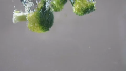 Close-up slow-motion footage of fresh vegetables dropping into water Video stock 107436613