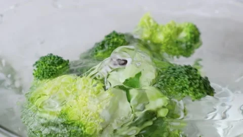 Close up slow motion of fresh broccoli splash in a bowl with water Video stock 147673640