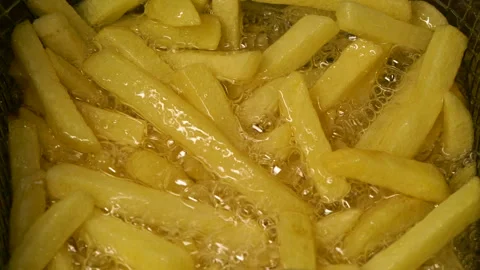 Close-up slow motion fried crispy potato wedges deep frying in oil. French fries Stock Footage 289507133