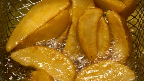 Close-up slow motion fried crispy potato wedges deep frying in oil. French fries 스톡 동영상 309506452