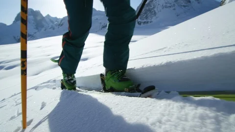 Close up slow motion of green ski boots on skis in white snow trail on sunny day Stock Footage 129126710