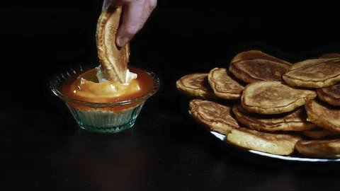 Close - Up, Slow Motion Hand of an Elderly Woman Puts a Pancake in Jam with Stock Footage 99605707