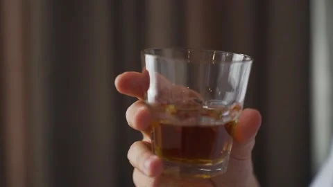 Close up Slow Motion Hand Holding A Glass Goblet With Whiskey Stock Footage 206067517