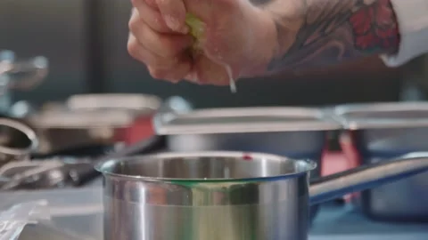 Close-up slow motion of hands of chef squeezing fresh lime for making sauce in Stock Footage 220269815