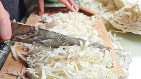 Close-up slow motion of hands finely slicing fresh cabbage on a wooden board Stock Footage 341934905
