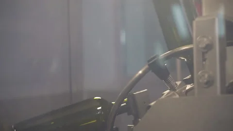 Close-up, slow-motion image of the movement of bottles on the conveyor. Stock Footage 155425698