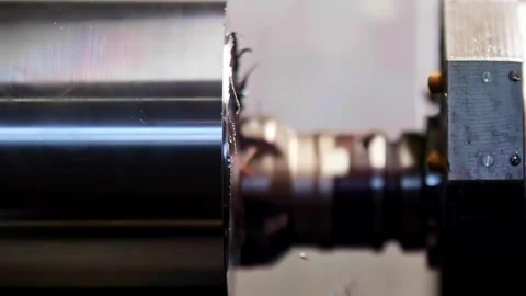 Close up slow motion of a metal lathe turning a steel cylinder, cutting tool Stock Footage 332922726