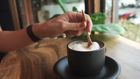 Close up Slow Motion ofHands Stirring Coffee withFoam With Wooden Spoon Stock Footage 109132543