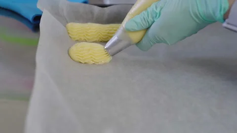 Close-up, Slow Motion, Pastry in Gloves Squeezes Dough for Eclairs on Metal Stock Footage 136800470