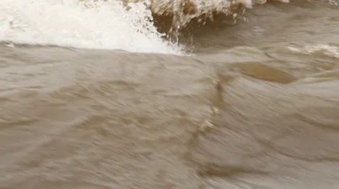 Close-up slow-motion rapids on a muddy river in flood Stock Footage