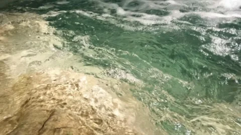 Close up slow motion ripples of clear turquoise river water Stock Footage 321860621