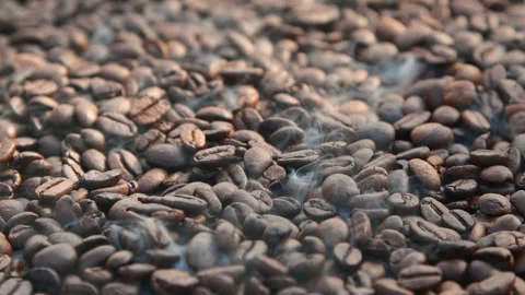 Close-up slow motion roasting coffee beans or seeds background with white smoke Stock Footage 312190394