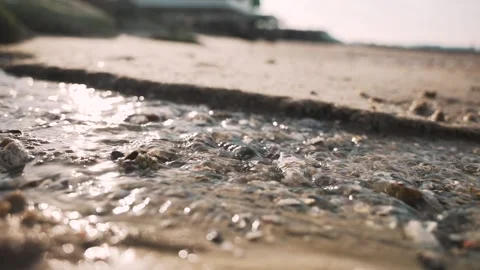 Close up slow motion of shallow water stream glistening under sunlight on sandy Stock Footage 315225403