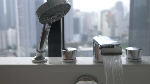 Close-up, slow-motion shooting, water pours from the tap into the tub. 4k Stock Footage 86481111