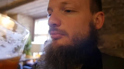 Close slow motion shot of bearded handsome man drinking non alcoholic beer in Stock Footage 124876343