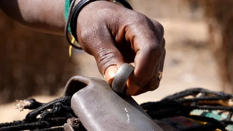 Close slow motion shot of black man playing kenken, metal ring on bell Stock Footage 113167129