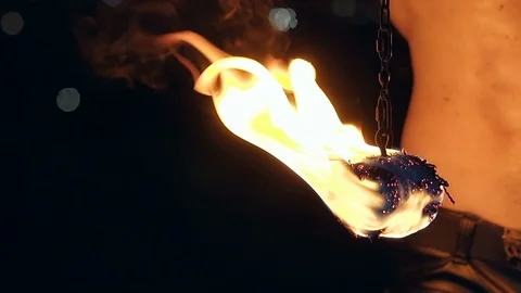 Close-up slow motion shot of burning poi hanging on chain. Stock Footage 105221185